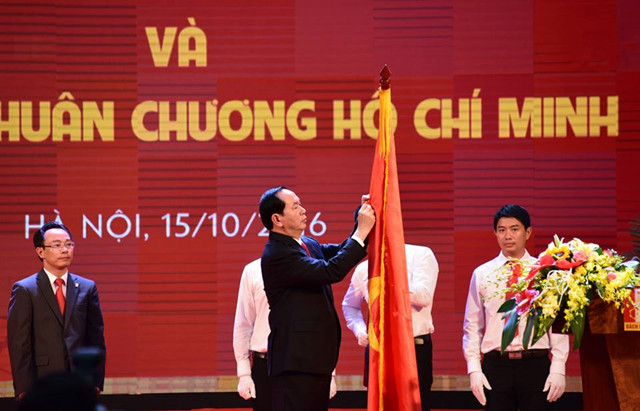 Description: Chủ tịch nước Trần Đại Quang gắn Huân chương Hồ Chí Minh lên lá cờ truyền thống của ĐHBK Hà Nội